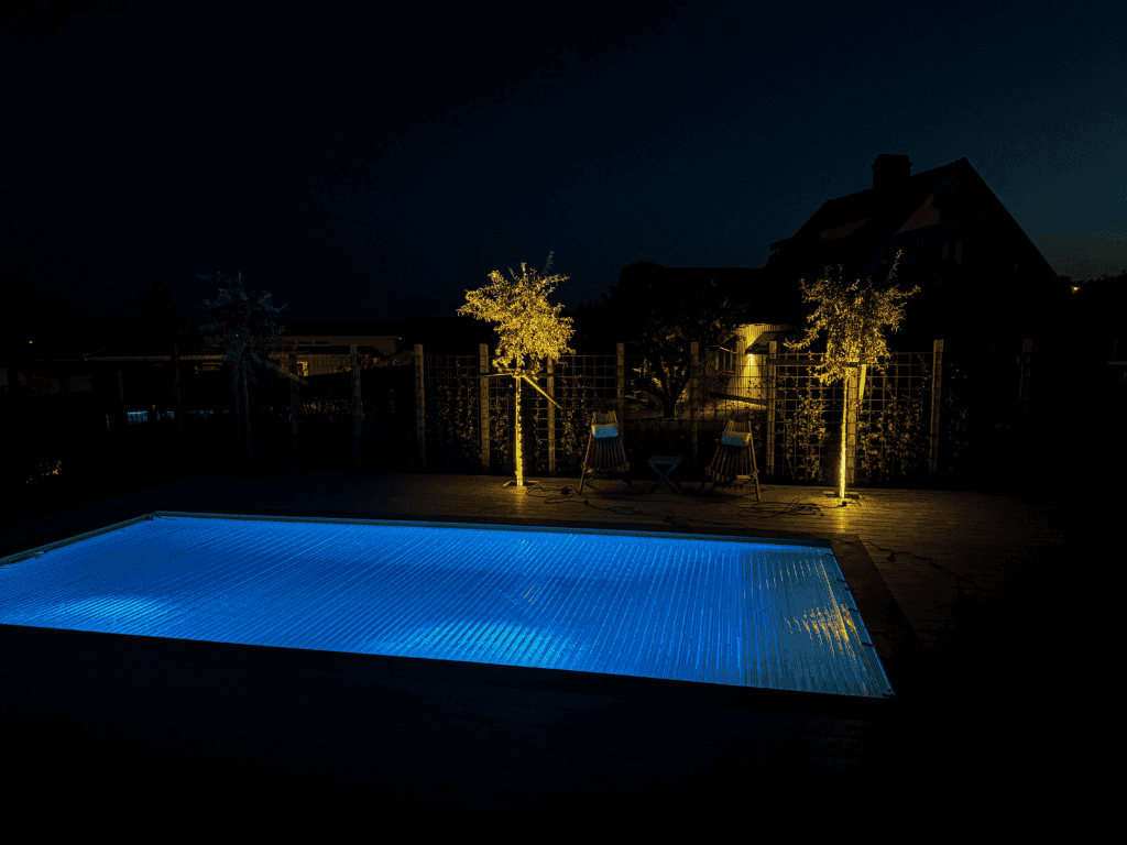 LED-lit swimming pool illuminated in blue during nighttime.